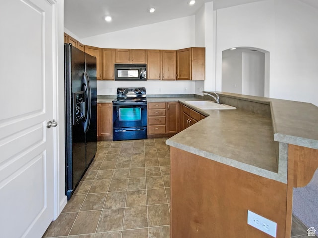 kitchen with brown cabinets, black appliances, a sink, a peninsula, and lofted ceiling