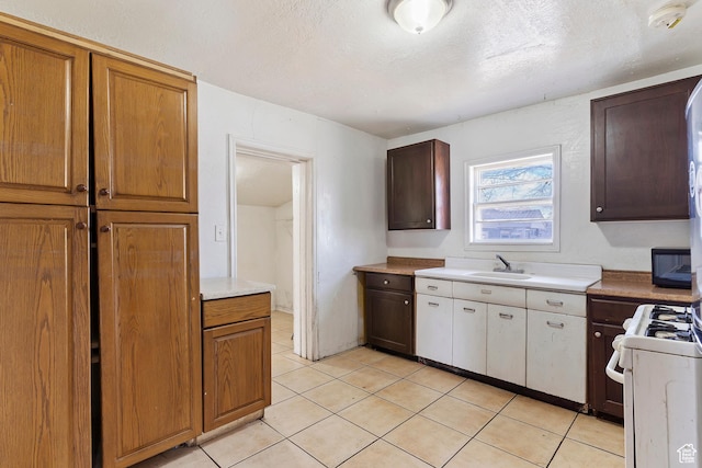 171 17th St, Ogden, UT 84404 - kitchen with a sink, white gas stove, light countertops, light tile patterned flooring, and a textured ceiling