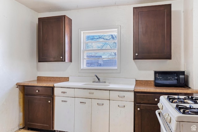171 17th St, Ogden, UT 84404 - kitchen featuring a sink, dark brown cabinetry, light countertops, and white cabinets