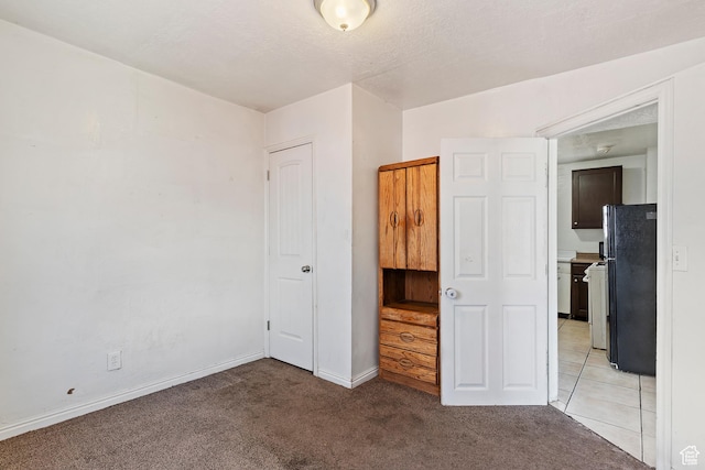 171 17th St, Ogden, UT 84404 - unfurnished bedroom with freestanding refrigerator, light colored carpet, and baseboards
