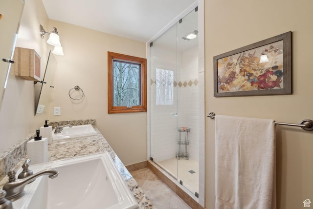 bathroom featuring tile patterned floors, double vanity, tiled shower, and a sink