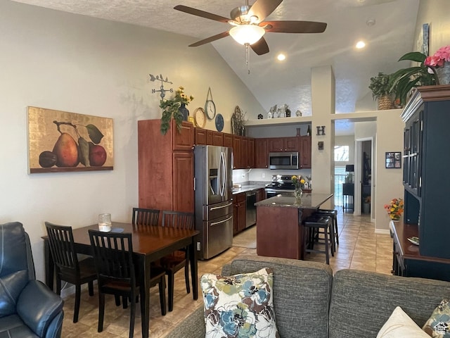 225 W Lyman Ln, Bountiful, UT 84010 - kitchen featuring a center island, ceiling fan, a breakfast bar, light tile patterned floors, and appliances with stainless steel finishes