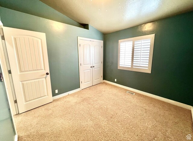 15 E 1100 S, Vernal, UT 84078 - unfurnished bedroom featuring visible vents, baseboards, vaulted ceiling, carpet flooring, and a closet