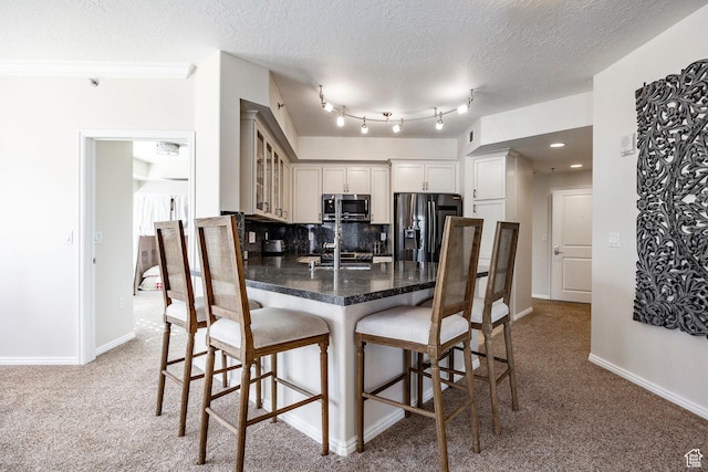 5 S 500 W Unit 908, Salt Lake City, UT 84101 - kitchen featuring dark countertops, stainless steel microwave, a kitchen bar, a peninsula, and black refrigerator with ice dispenser