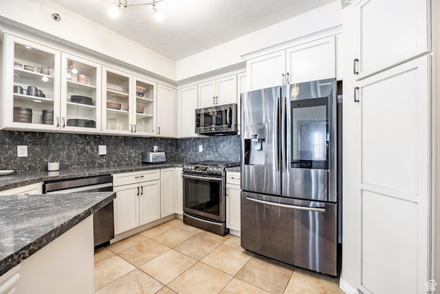 5 S 500 W Unit 908, Salt Lake City, UT 84101 - kitchen featuring decorative backsplash, white cabinets, light tile patterned floors, and stainless steel appliances