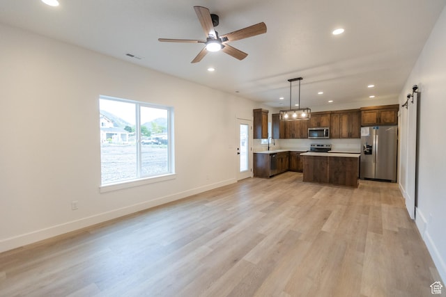 1183 S 1335 E Unit 76, Garland, UT 84312 - kitchen featuring visible vents, light countertops, appliances with stainless steel finishes, a barn door, and open floor plan