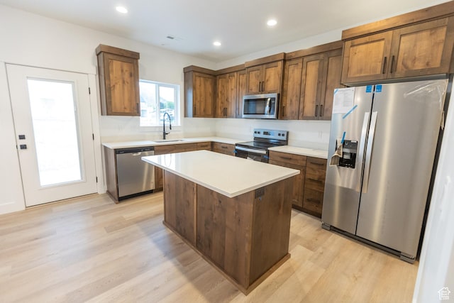 1183 S 1335 E Unit 76, Garland, UT 84312 - kitchen with a sink, a center island, stainless steel appliances, light wood-style floors, and light countertops