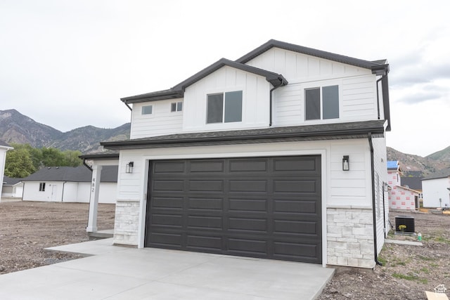 1183 S 1335 E Unit 76, Garland, UT 84312 - view of front facade featuring driveway, a mountain view, an attached garage, central AC, and board and batten siding