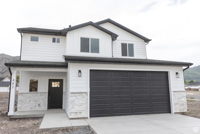 1183 S 1335 E Unit 76, Garland, UT 84312 - view of front of property featuring stone siding, a garage, board and batten siding, and driveway