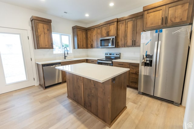 1183 S 1335 E Unit 76, Garland, UT 84312 - kitchen featuring a sink, light countertops, light wood-style floors, appliances with stainless steel finishes, and a center island