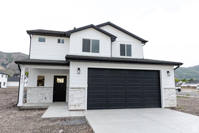 1183 S 1335 E Unit 76, Garland, UT 84312 - view of front of property with board and batten siding, a porch, concrete driveway, a garage, and a mountain view