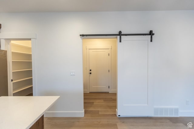 1183 S 1335 E Unit 76, Garland, UT 84312 - interior space with visible vents, light wood-style flooring, baseboards, and a barn door
