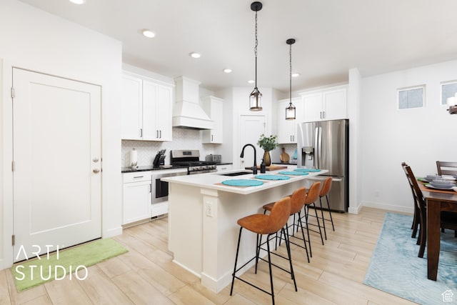 4672 W Tulip N, Cedar Hills, UT 84062 - kitchen featuring tasteful backsplash, a breakfast bar area, an island with sink, custom exhaust hood, and stainless steel appliances
