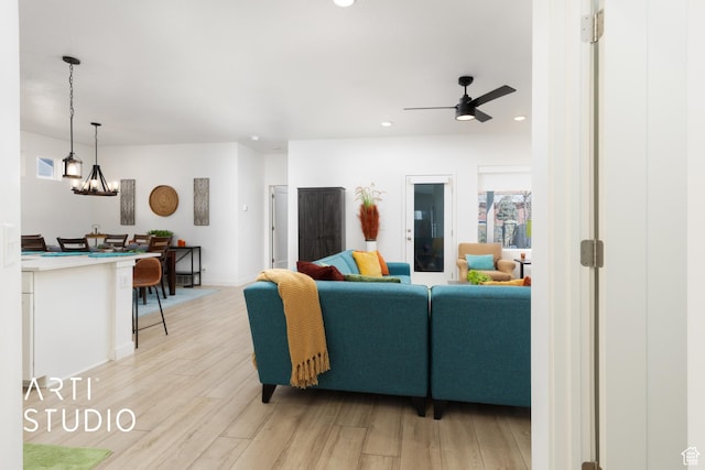 4672 W Tulip N, Cedar Hills, UT 84062 - living room with light wood finished floors, recessed lighting, ceiling fan with notable chandelier, and baseboards