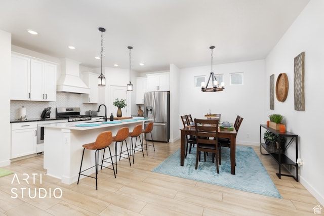 4672 W Tulip N, Cedar Hills, UT 84062 - kitchen with custom range hood, backsplash, appliances with stainless steel finishes, a breakfast bar area, and white cabinets