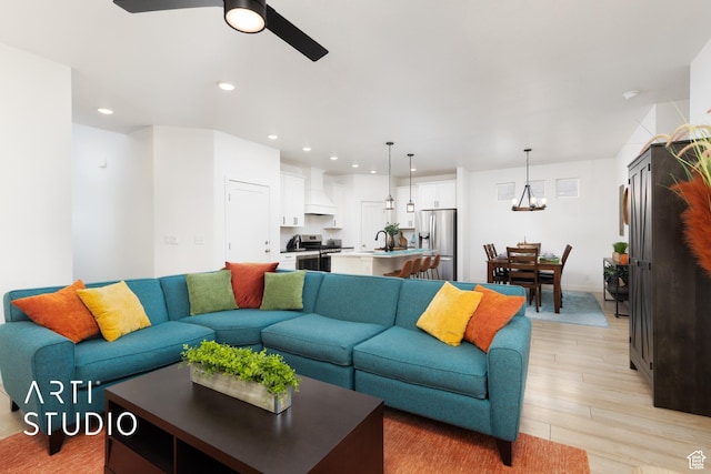 4672 W Tulip N, Cedar Hills, UT 84062 - living room featuring ceiling fan with notable chandelier, recessed lighting, and light wood finished floors
