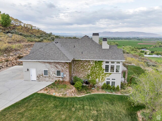 2382 S Spanish Oaks Dr, Spanish Fork, UT 84660 - rear view of house with roof with shingles, a chimney, a lawn, and stucco siding