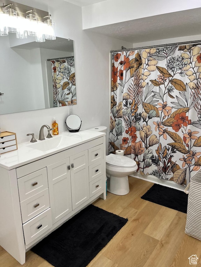 1036 S Fir St, Cedar City, UT 84720 - full bathroom with vanity, a shower with curtain, toilet, and wood finished floors