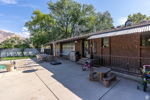 717 E Park Dr N, Hyrum, UT 84319 - view of patio / terrace with outdoor dining area, a grill, a mountain view, and fence