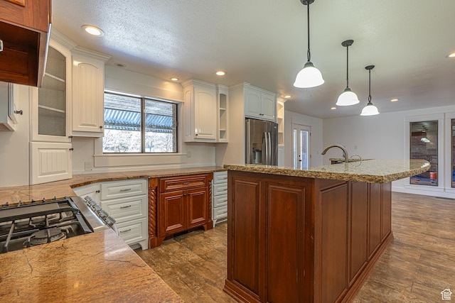 717 E Park Dr N, Hyrum, UT 84319 - kitchen with stainless steel refrigerator with ice dispenser, open shelves, light countertops, glass insert cabinets, and dark wood-style flooring