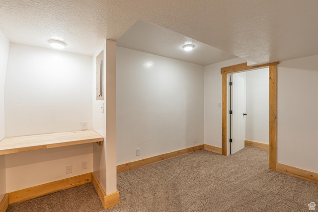 717 E Park Dr N, Hyrum, UT 84319 - basement featuring carpet flooring, baseboards, built in desk, and a textured ceiling