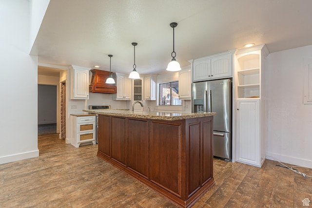 717 E Park Dr N, Hyrum, UT 84319 - kitchen featuring light stone countertops, dark wood-type flooring, stainless steel refrigerator with ice dispenser, and custom range hood
