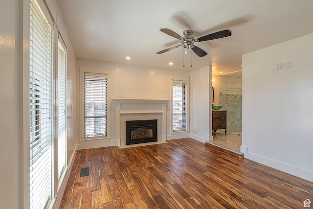 717 E Park Dr N, Hyrum, UT 84319 - unfurnished living room with dark wood finished floors, a fireplace with flush hearth, baseboards, and plenty of natural light