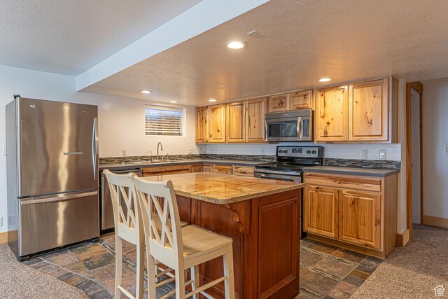 717 E Park Dr N, Hyrum, UT 84319 - kitchen featuring stone tile floors, recessed lighting, a sink, appliances with stainless steel finishes, and a textured ceiling