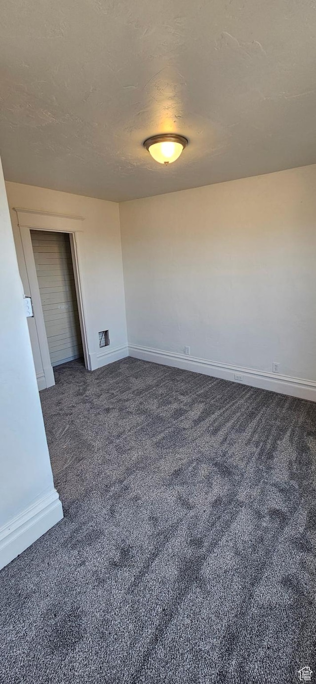 279 E 2nd St N, Downey, ID 83234 - unfurnished room with a textured ceiling, baseboards, and dark colored carpet