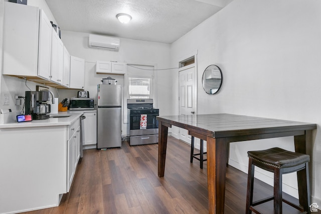 739 24th St, Ogden, UT 84401 - kitchen with a wall mounted AC, a sink, white cabinetry, stainless steel appliances, and dark wood-style flooring