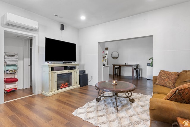 739 24th St, Ogden, UT 84401 - living room featuring visible vents, a glass covered fireplace, wood finished floors, a wall unit AC, and recessed lighting