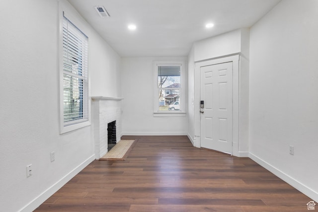 739 24th St, Ogden, UT 84401 - entryway with a wealth of natural light, visible vents, a brick fireplace, and dark wood-style floors