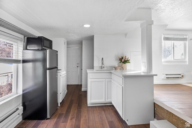 739 24th St, Ogden, UT 84401 - kitchen with a sink, freestanding refrigerator, black microwave, light countertops, and dark wood-style flooring