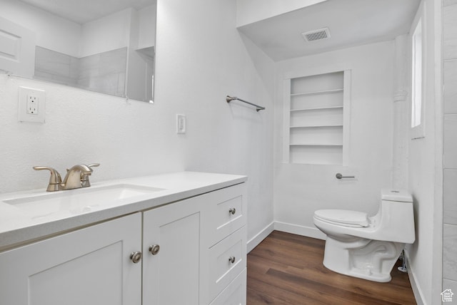 739 24th St, Ogden, UT 84401 - bathroom featuring visible vents, built in features, toilet, wood finished floors, and vanity