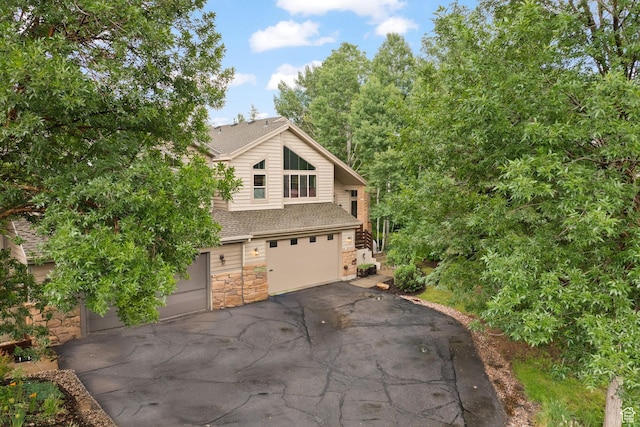 7494 Brook Hollow Loop Rd, Park City, UT 84098 - view of side of property featuring stone siding, a shingled roof, an attached garage, and driveway