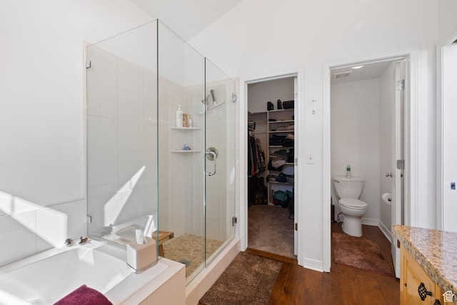 7494 Brook Hollow Loop Rd, Park City, UT 84098 - bathroom with a spacious closet, a shower stall, toilet, a garden tub, and wood finished floors