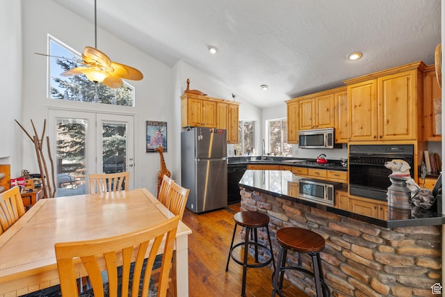 7494 Brook Hollow Loop Rd, Park City, UT 84098 - kitchen with dark wood finished floors, a sink, black appliances, vaulted ceiling, and dark countertops