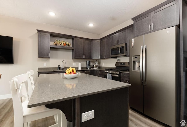 3180 W 1650 N Unit B, Cedar City, UT 84721 - kitchen featuring light stone counters, light wood finished floors, open shelves, dark brown cabinetry, and appliances with stainless steel finishes