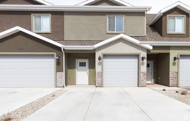 townhome / multi-family property with brick siding and stucco siding