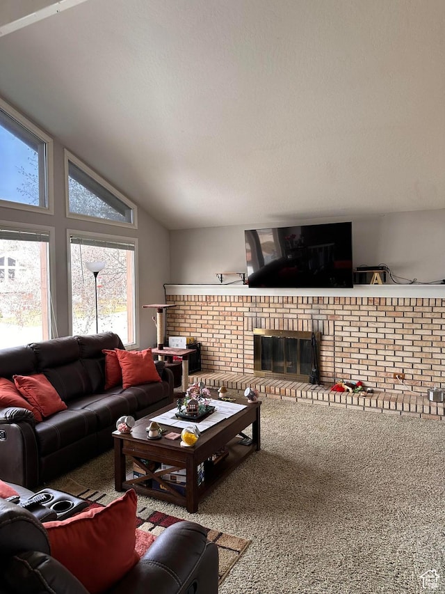 living room featuring vaulted ceiling, a brick fireplace, and carpet