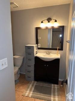 bathroom with vanity, tile patterned floors, and toilet