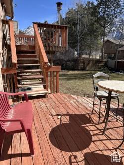 deck with outdoor dining area and stairs