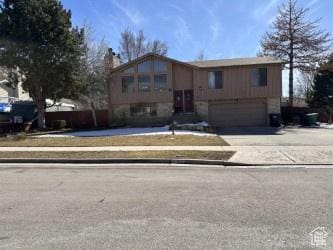 raised ranch with concrete driveway and a garage