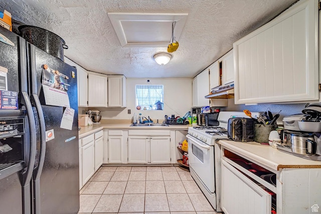 kitchen with white gas stove, light countertops, black refrigerator with ice dispenser, light tile patterned flooring, and a sink