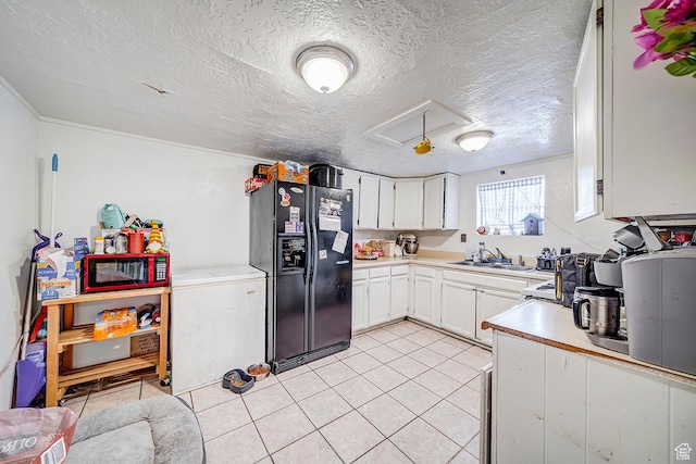 kitchen with white cabinetry, light countertops, a sink, and black refrigerator with ice dispenser