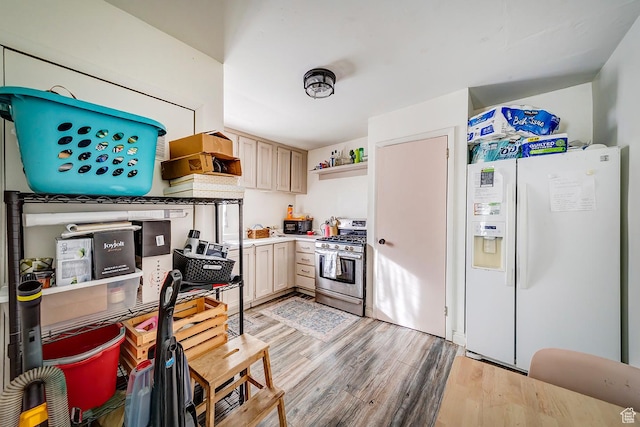 kitchen featuring stainless steel range with gas stovetop, light countertops, white refrigerator with ice dispenser, light wood-style floors, and open shelves
