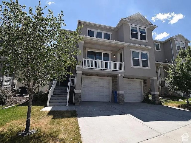 view of property featuring an attached garage, driveway, stucco siding, and stone siding