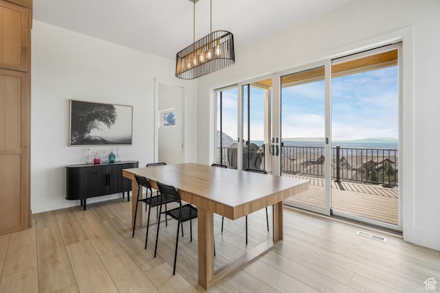 dining room featuring light wood finished floors, visible vents, and baseboards