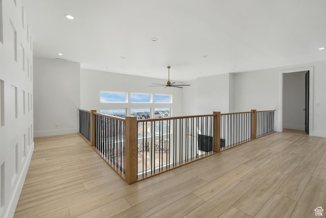 hallway featuring recessed lighting, baseboards, and light wood-style flooring