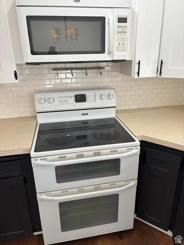 kitchen with dark wood finished floors, white cabinetry, white appliances, light countertops, and decorative backsplash